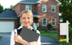 Lady with clipboard outside house