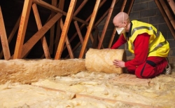 Man unrolling loft insulation